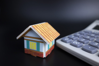 黑色背景中放着小房子和计算器