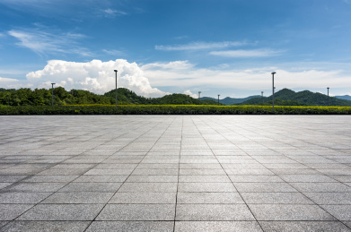 阳光下的山峦树木和花岗岩道路地面