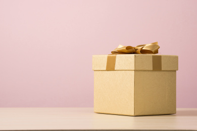 粉色背景前，神秘的金色礼盒