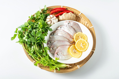 白背景上一竹盘装着新鲜红鲷鱼和香料食材
