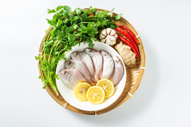 白背景上一竹盘装着新鲜红鲷鱼和香料食材