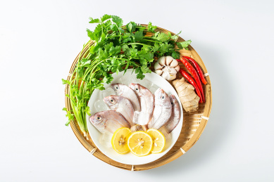 白背景上一竹盘装着新鲜红鲷鱼和香料食材