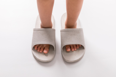 一双小脚穿在一双巨大的拖鞋里