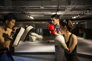 三个青年男女在健身房练习拳击