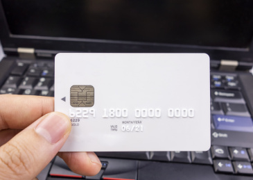 电脑键盘上放着的手里拿着银行卡