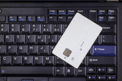 电脑键盘上放着的手里拿着银行卡