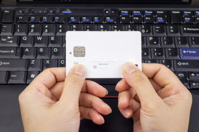 电脑键盘上放着的手里拿着银行卡