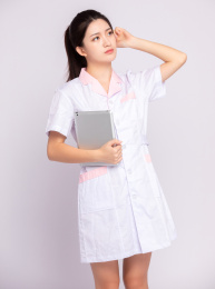 灰色背景里，手拿平板电脑的年轻女医师