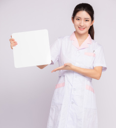 灰色背景里，拿着白板的年轻女医师