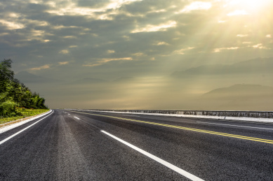 一条穿过有丁达尔现象山峦间的柏油路