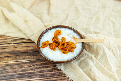 木纹桌面上瓷碗里的白米粥与萝卜干