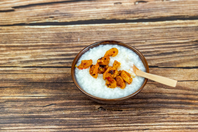 木纹桌面上瓷碗里的白米粥与萝卜干