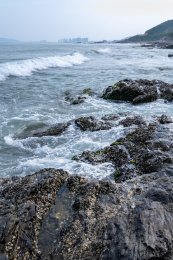 蔚蓝大海上的浪花和海岸边礁石