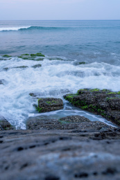 蔚蓝大海上的浪花和海岸边礁石