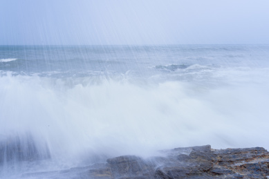 蔚蓝大海上的浪花和海岸边的礁石