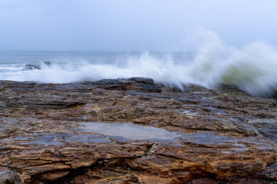 蔚蓝大海上的浪花和海岸边的礁石