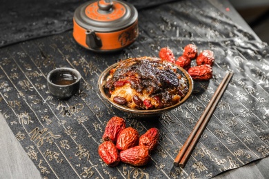 黑色瓷碗里放着一块豆沙枣泥的甄糕