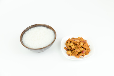 白背景中的凉拌红油萝卜干与白米粥