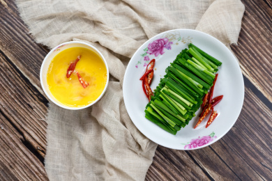 盘子里的绿色韭菜和小碗里的鸡蛋清