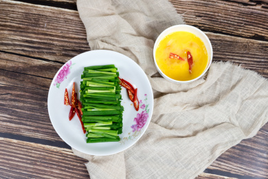 盘子里的绿色韭菜和小碗里的鸡蛋清