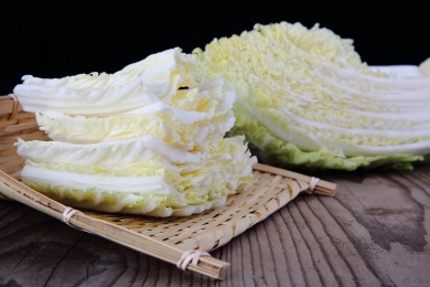 切开的大白菜和一簸箕白菜片放在木桌上