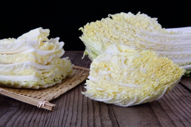 切开的大白菜和一簸箕白菜片放在木桌上
