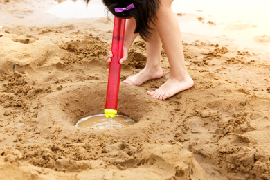 小孩子在水边光脚丫玩泥沙