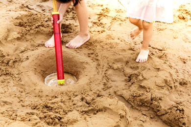 两个小孩子光脚丫玩水枪，泥沙