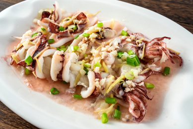 中国粤菜家常菜，一碟蒜蓉清蒸鱿鱼在木板背景上