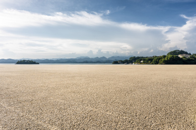 阳光下的海滨风光和碎石铺装道路地面