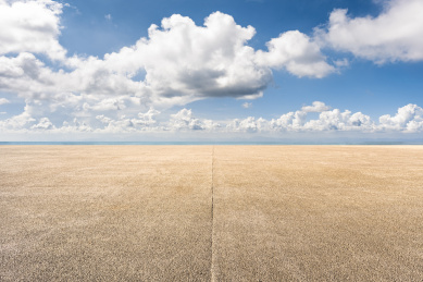 阳光下的海滨风光和碎石铺装道路地面