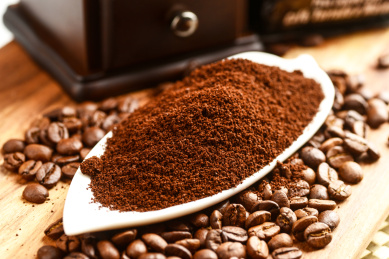 白色碟子旁散落咖啡豆的咖啡粉