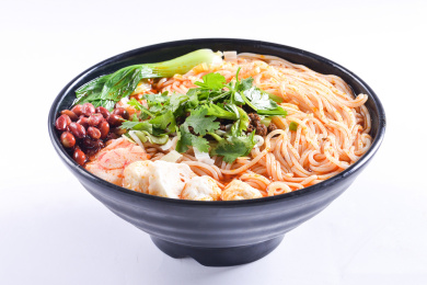 一份黑色碗盛的麻辣米粉放在白色底板上