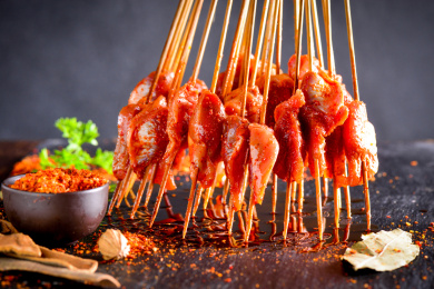 手拿着烧烤串串在碳火烤架烤鸡胗鸭胗郡片