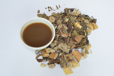 一剂治疗感冒咳嗽的中草药材和一碗煎好的中草药汤