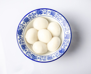 青花瓷小碗里装着六个煮好的汤圆