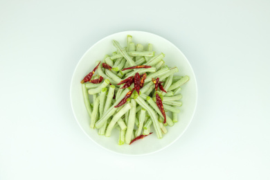 白色圆盘子里的新鲜绿色蔬菜豇豆