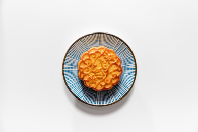 白色背景上摆放着茶壶和月饼