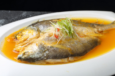 白色盘子里的清蒸黄花鱼