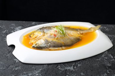 白色盘子里的清蒸黄花鱼