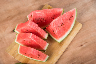 木板背景上放着几片红色的西瓜