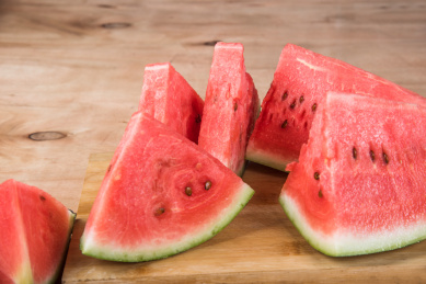 红色的几片西瓜放在木板背景上