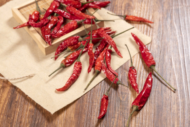 红色的干辣椒与大蒜摆放在木质桌面上