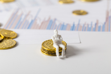 经济数据分析表和金币金融题材背景的白色小人模型微距特写