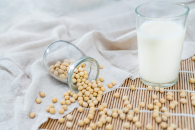 竹席上的许多大豆和一杯豆浆