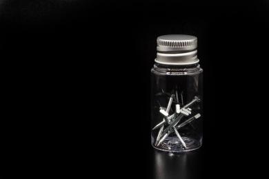 黑色背景塑料瓶装金属钉子