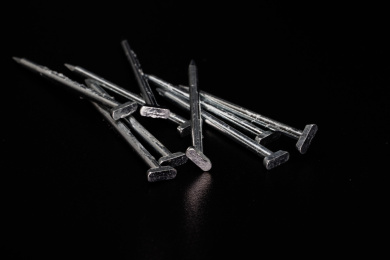 黑色背景下杂乱堆放的金属钉子