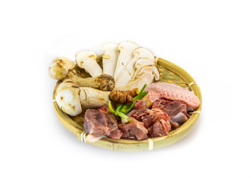 白背景竹编簸箕里的松茸炖鸡食材原料