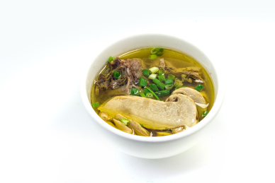 白色背景瓷碗里乘的松茸炖鸡汤