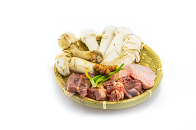 白背景竹编簸箕里的松茸炖鸡食材原料